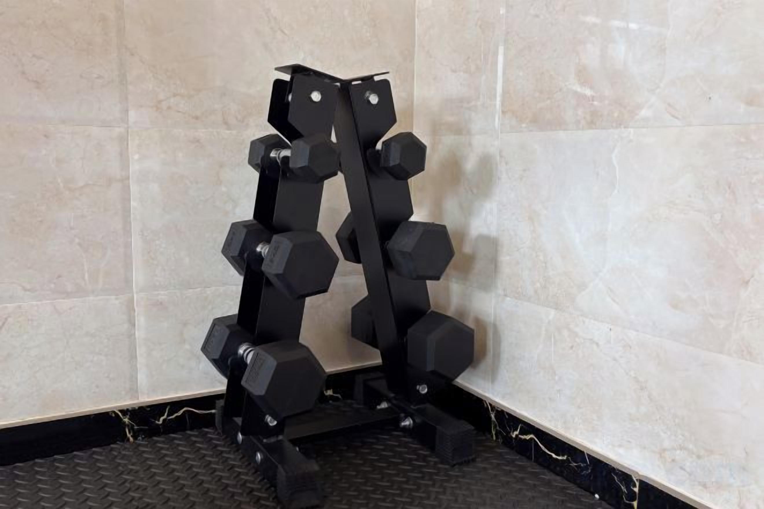 A corner with a tiled wall and a black floor.