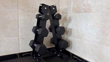 A corner with a tiled wall and a black floor.