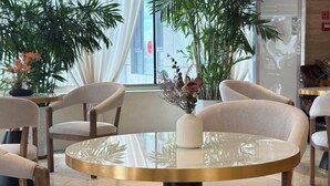 Ein modernes Interieur mit runden Tischen, Stühlen und Topfpflanzen.