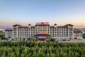 A multi-story hotel with a central courtyard, surrounded by greenery. - Jiangsu Guoji Hotel (Zhaosu)