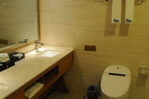 A bathroom with a sink, mirror, and toilet.