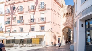A pink building with balconies and a cafe named "Cruzcampo" at the ground level. - Posadilla Apartment Cádiz (Cádiz)