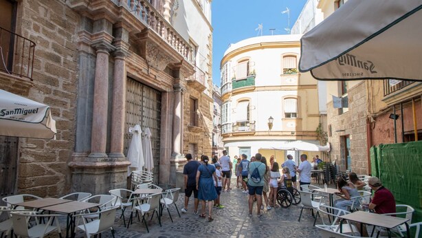 A cobblestone street with outdoor seating, historic buildings, and a clear blue sky. - Posadilla Apartment Cádiz (Cádiz)