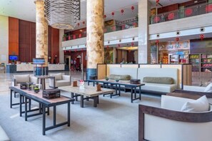 A spacious lobby with multiple seating areas, including sofas and tables, and a large digital screen. - Changting Hotel (Changting)