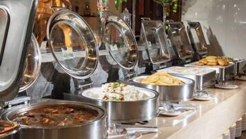 A buffet with various food items and utensils.