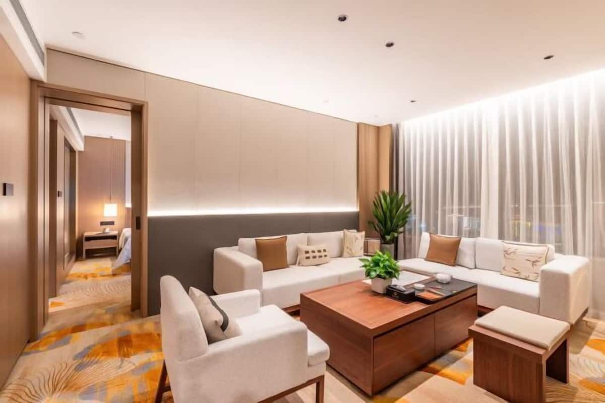 Una habitación de hotel moderna con un conjunto de sofás, una mesa de centro y una planta.