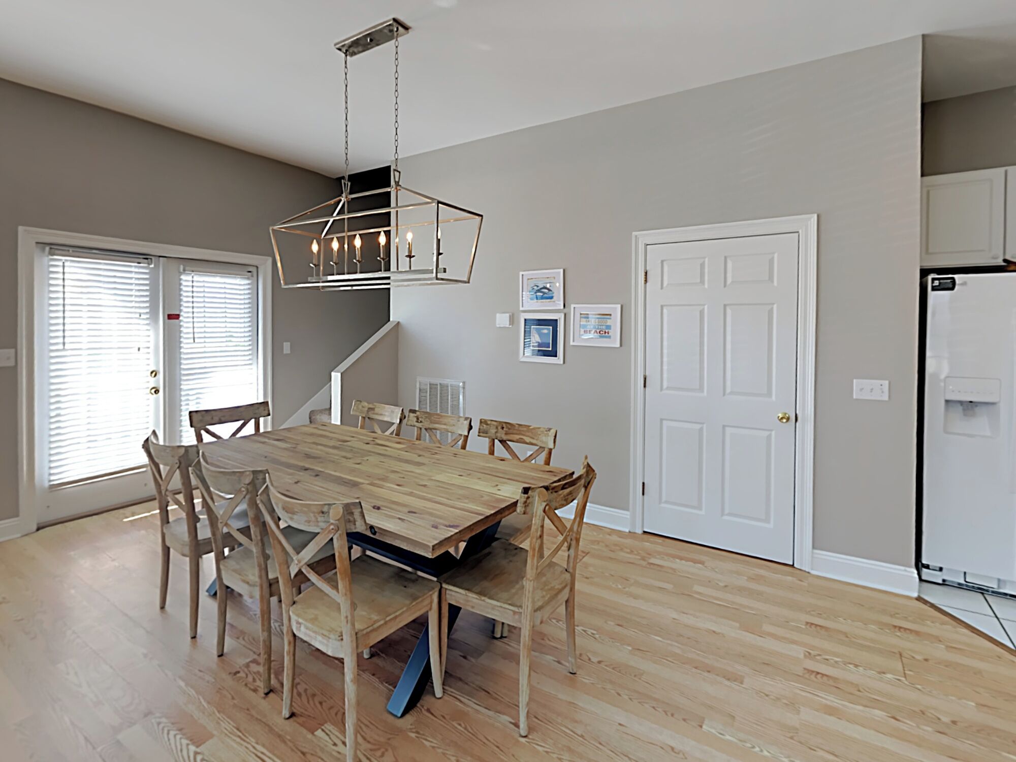 Ein Esszimmer mit Holztisch und Stühlen, einer Kandelaber und einem Kühlschrank.