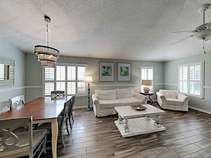 Relax in this stylish living room with a dining area, sofa, and coffee table.