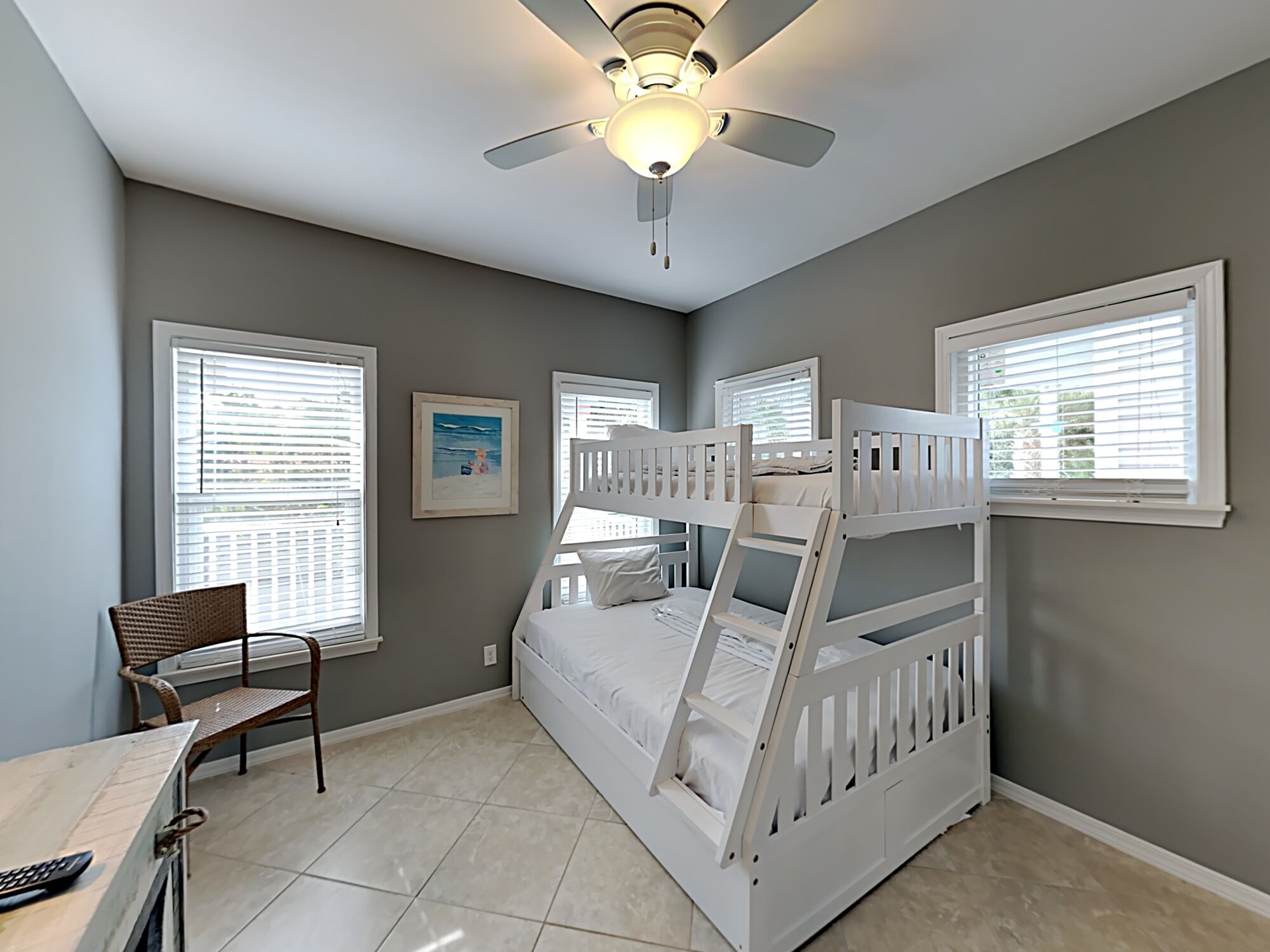 A bedroom with bunk beds, a desk, and a chair.