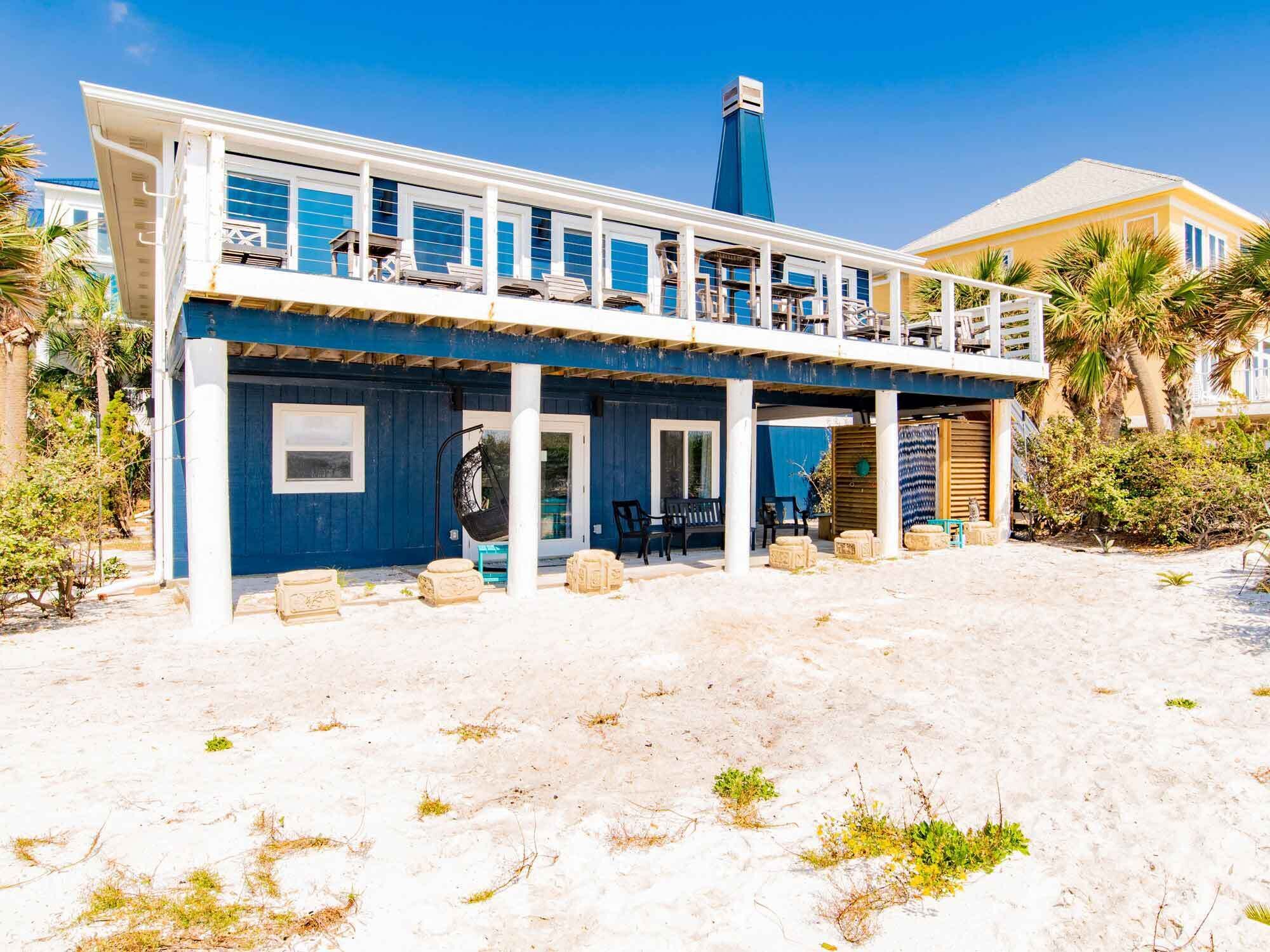 Un bâtiment à deux étages situé en bord de mer, doté d’un balcon, d’un espace extérieur aménagé pour s’asseoir et d’une piscine.