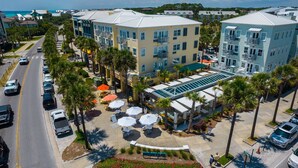 A multi-story hotel with a central courtyard, outdoor seating, and a pool area. - Gulf Place Six Palms #2B - BB's Hideaway by Southern Vacation Rentals (Santa Rosa Beach)
