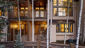 A multi-story building with a wooden exterior, a balcony on the upper floor, and a stone staircase leading to the entrance. - 5 Beds in BC - Ski In, Hot Tub, Pool (Beaver Creek)