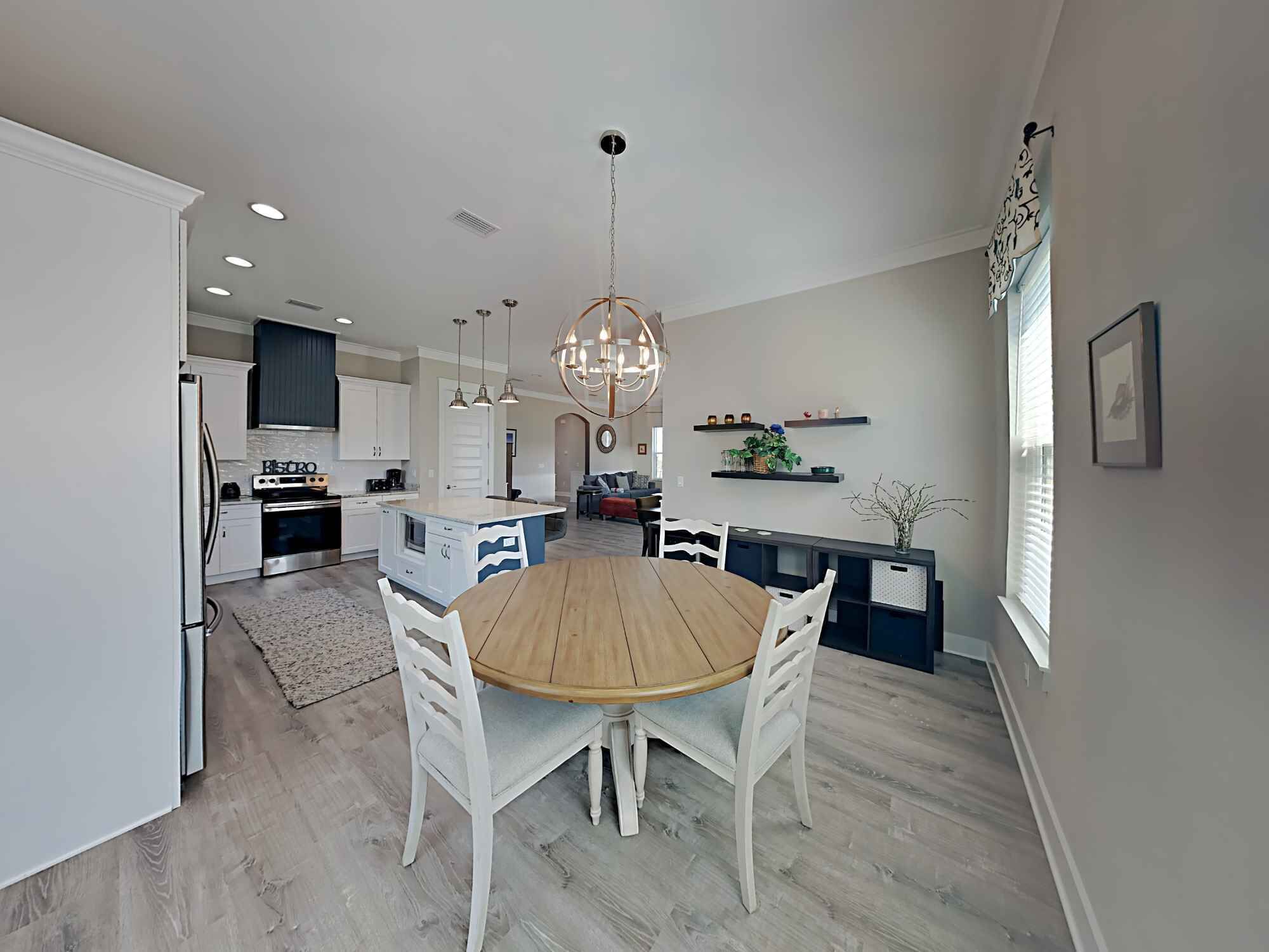 A modern kitchen with white cabinets, a central island, and pendant lighting.