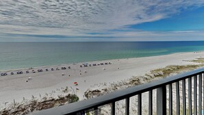 A beach with umbrellas and lounge chairs, a clear sky, and a view of the ocean. - Phoenix X by Southern Vacation Rentals (Orange Beach)