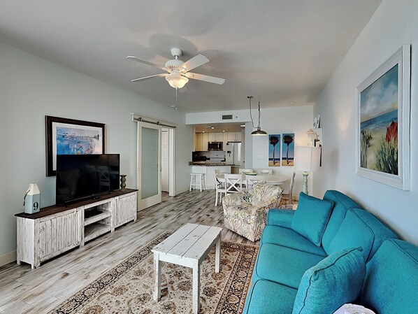 A living room with a television, sofa, coffee table, and a patterned rug. - Phoenix X by Southern Vacation Rentals (Orange Beach)