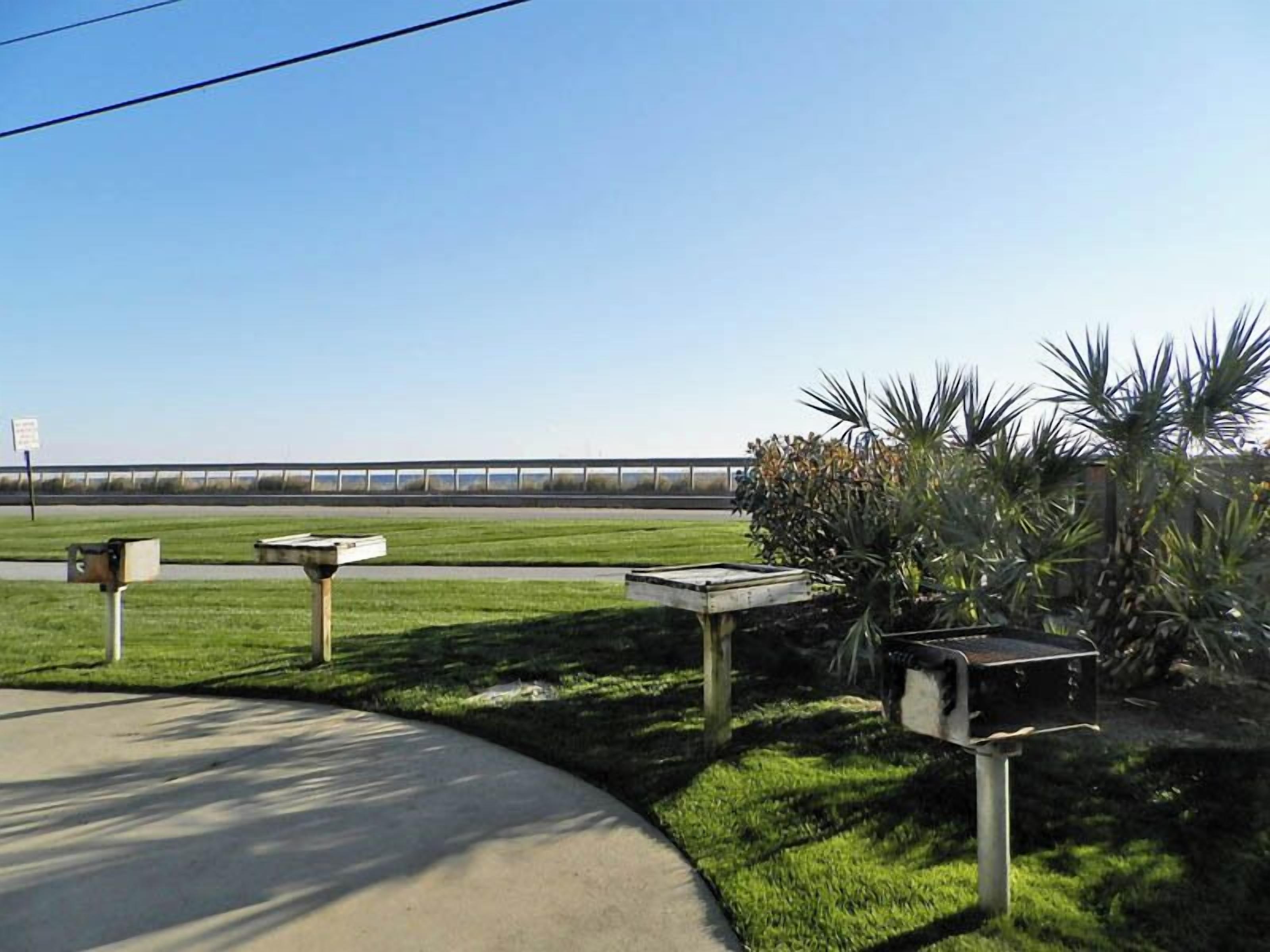 A parking area with concrete pathways and mailbox posts.