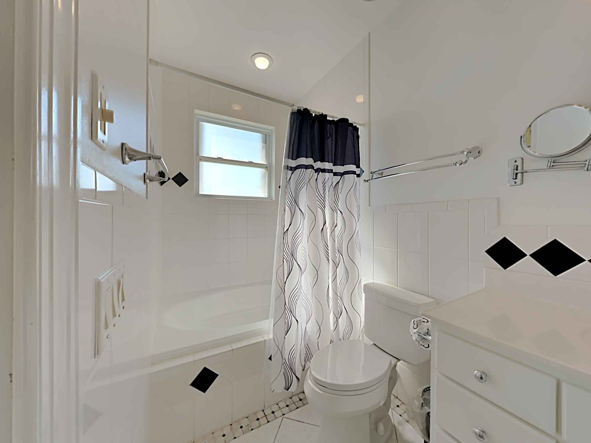 A bathroom with a bathtub, toilet, and sink.