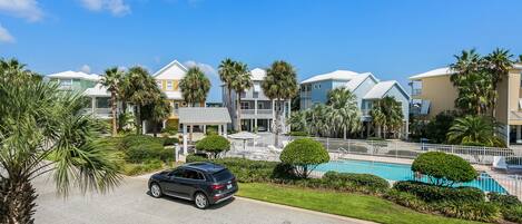 A residential area with houses, a swimming pool, and a parked car.