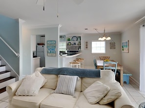 Relax in this inviting living space with a sofa, dining area, and kitchen, perfect for unwinding and enjoying time with loved ones.