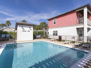 A swimming pool with lounge chairs and a building labeled "Leisure Bay" in the background.