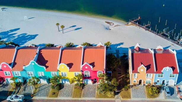 A coastal area with colorful buildings, a beach, and a marina.