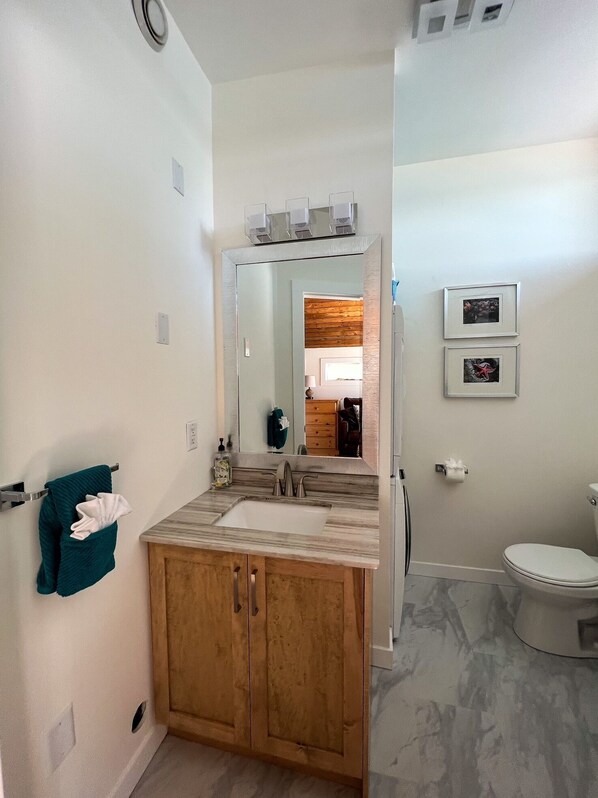 Een bad/douchecombinatie, een haardroger, handdoeken, zeep