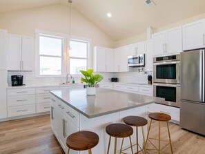 Prepare meals and dine in comfort at this kitchen with a spacious island and stainless steel appliances.