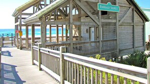 A wooden boardwalk leading to a beach house named 'Emerald Shores'. - Changes In Latitude by Southern Vacation Rentals (Miramar Beach)