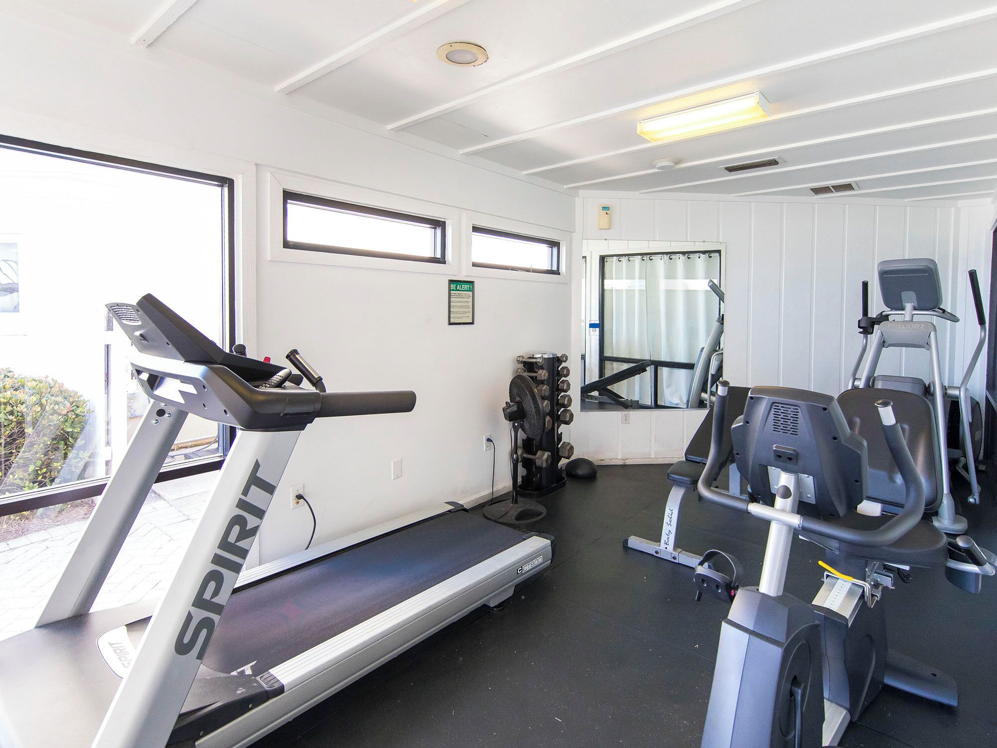 A gym with treadmills, a stationary bike, and a weight machine.
