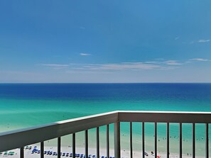 Ein Balkon mit Blick auf Strand und Meer.