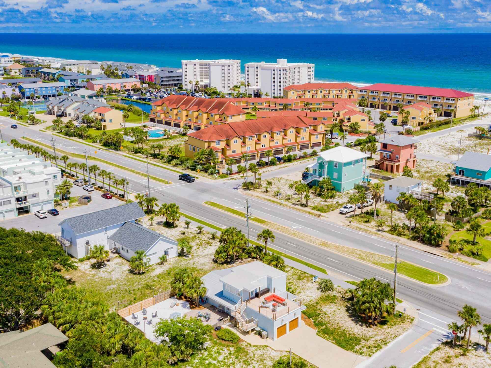 Zona hotelera frente al mar con varios edificios, una piscina y vistas al océano.