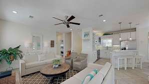 A modern living room with a sofa, coffee table, and a ceiling fan. - Aloha Sandy Bay by Southern Vacation Rentals (Santa Rosa Beach)