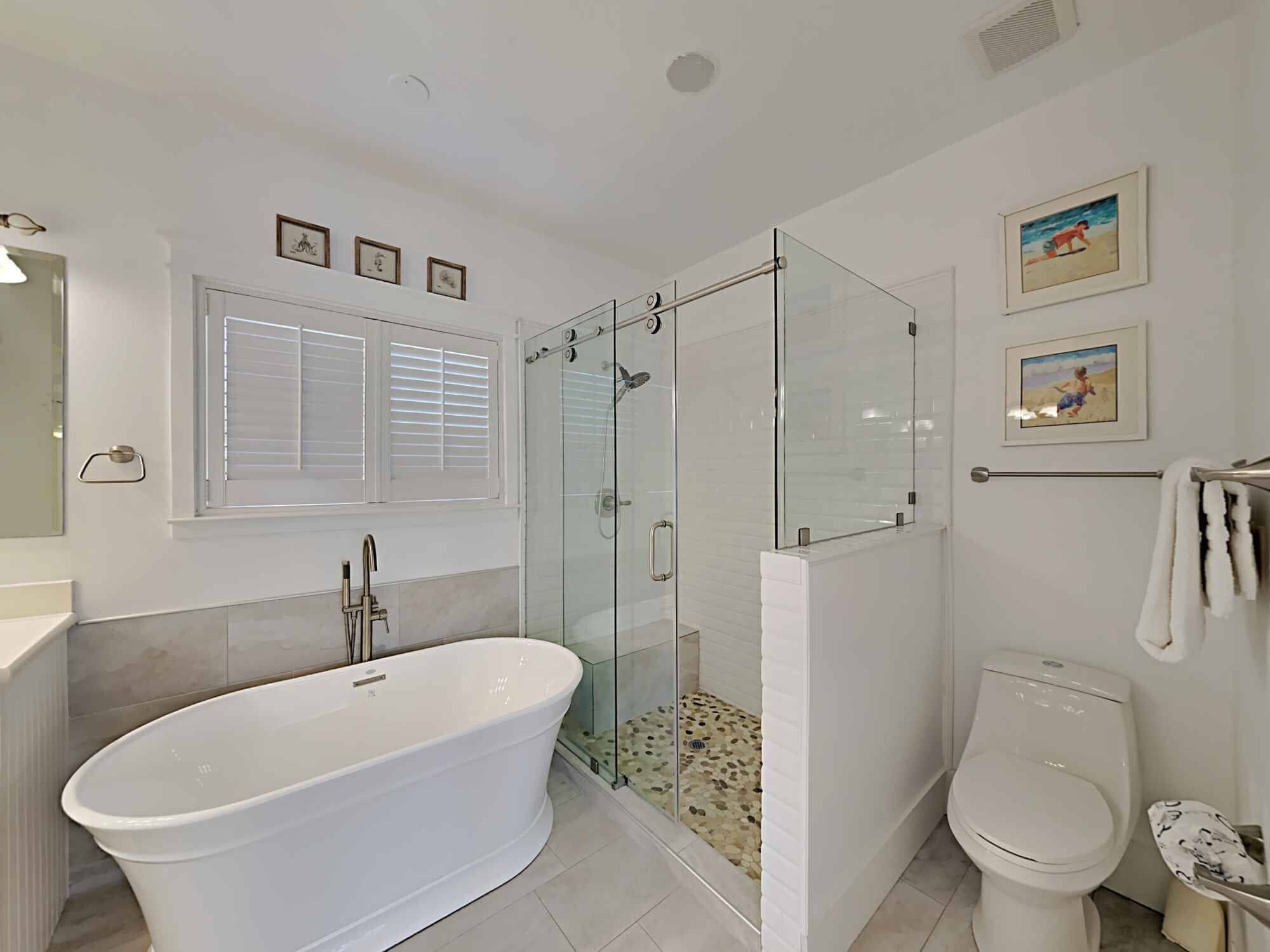 A modern bathroom with a freestanding bathtub, a glass-enclosed shower, and a toilet.