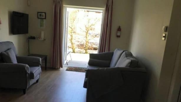 A living room with two sofas, a television on the wall, and a door leading to a balcony. - distance 2 minutes Adare Village  Manor, Hotels, Restaurant’s, Pubs, Golf Course (Adare)