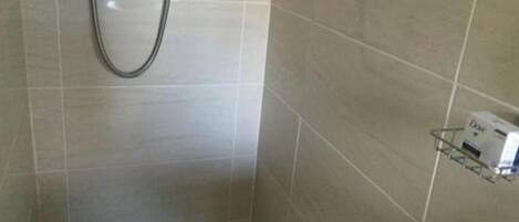 A bathroom with a shower, a toilet, and a sink.