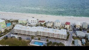 An aerial view of a coastal hotel with multiple buildings, a beach in the background, and a swimming pool. - 3 Bedroom, Gulf View, Orange Beach Condo--A Boardwalk to Salt Life (Orange Beach)