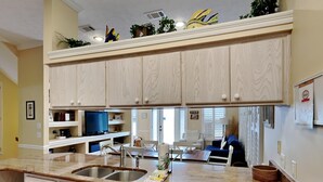 A kitchen with light wood cabinets, a double sink, a dishwasher, and a countertop with a coffee maker. - Camellia House by Southern Vacation Rentals (Santa Rosa Beach)