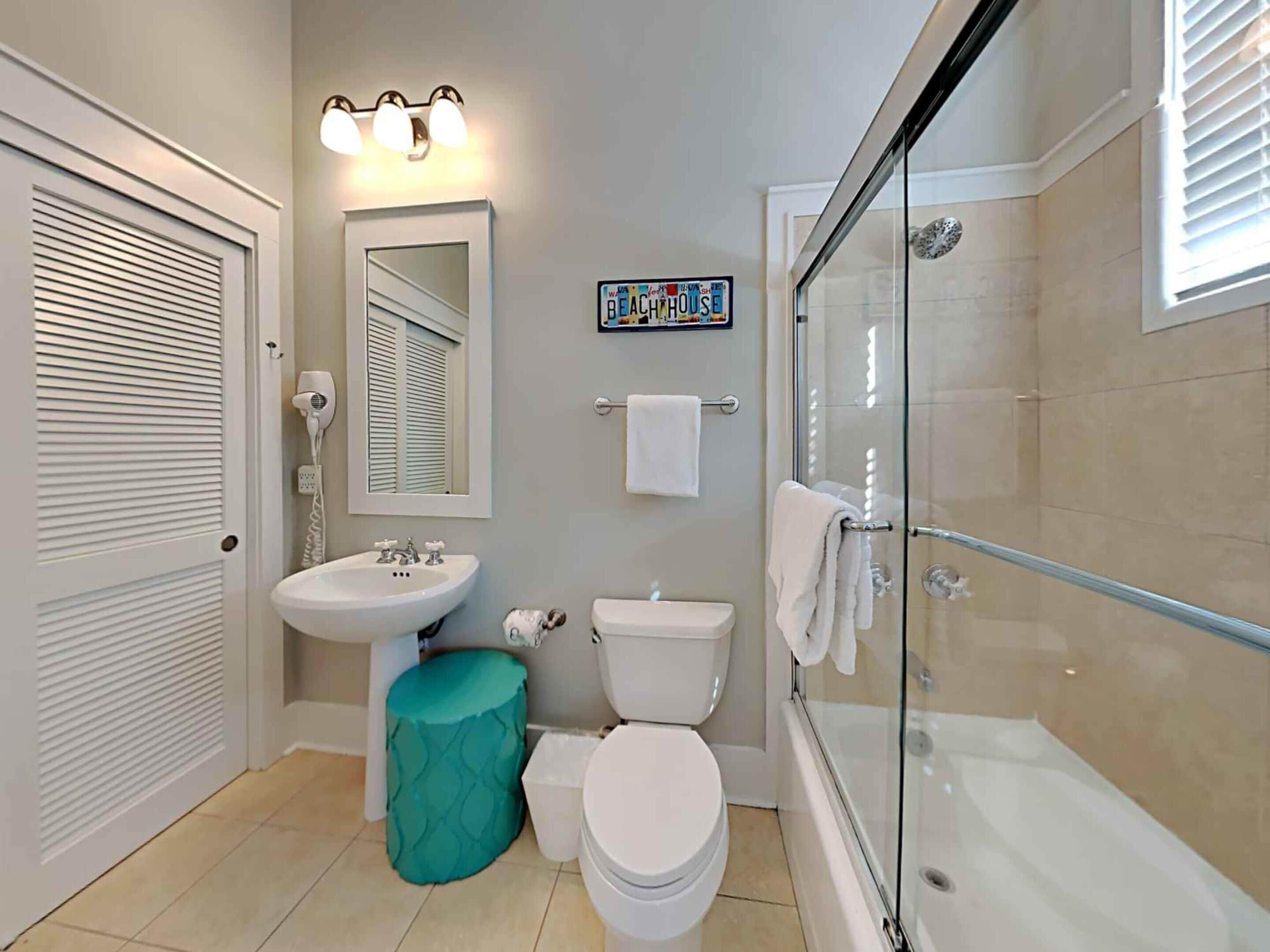 A bathroom with a sink, toilet, and glass-enclosed shower.