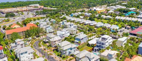 A residential area with multiple two-story houses, roads, and a body of water in the background.