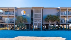 A beachfront hotel with a modern design, featuring a prominent logo and the name 'Spinnaker' on the facade. - Spinnaker #2A by Southern Vacation Rentals (Pensacola)