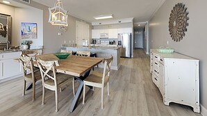 Eine moderne Küche mit einem Holzespeisetisch, weißen Schränken und Edelstahlgeräten.