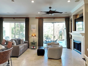 Relax in this stylish living room with a fireplace, television, and comfortable seating area.