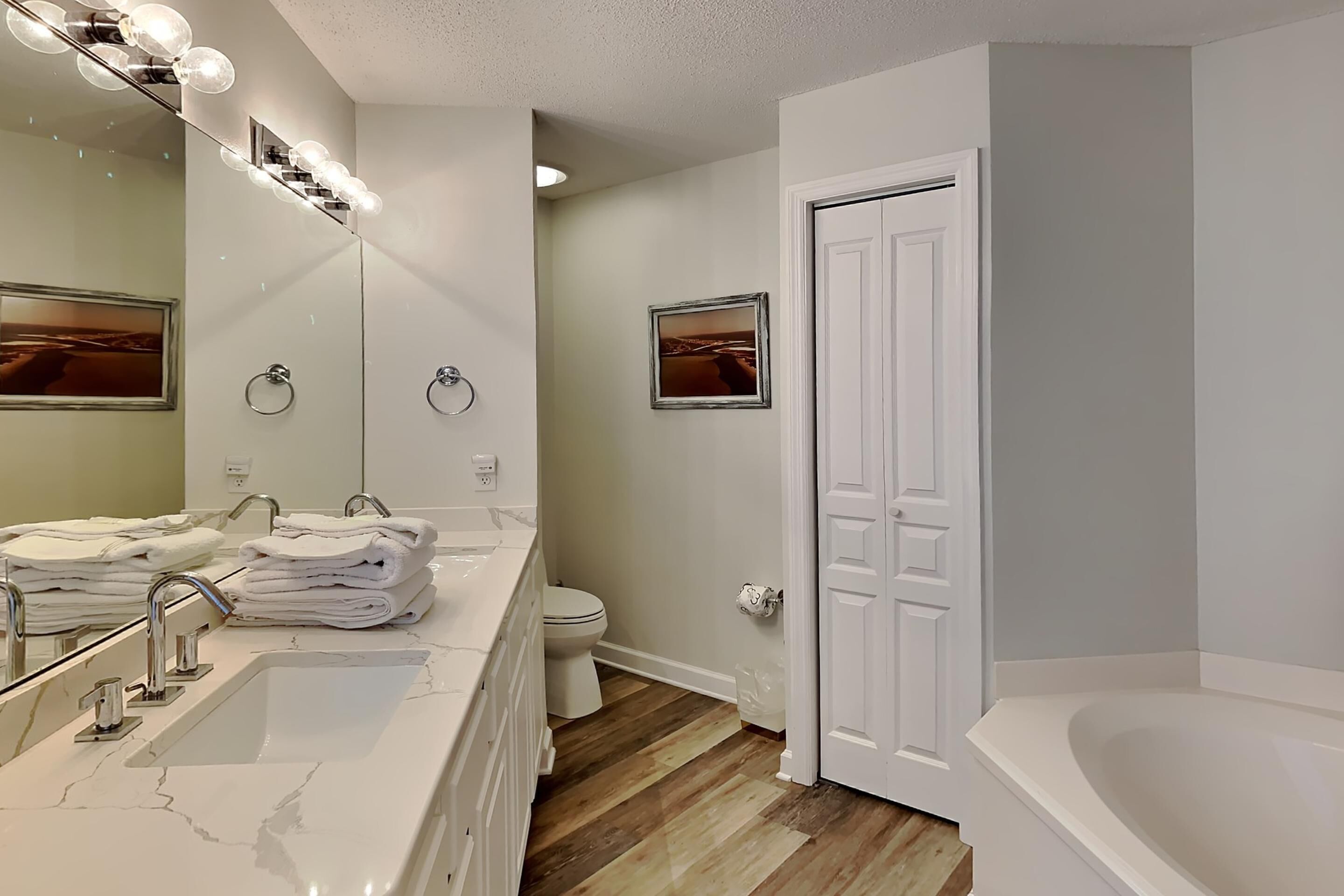 Une salle de bain moderne avec un grand miroir, un meuble-lavabo et une baignoire.