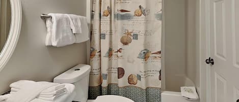 Une salle de bain équipée de toilettes, d’un lavabo et d’un rideau de douche sur le thème de la marine.