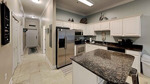 A modern kitchen with white cabinets, stainless steel appliances, and a granite countertop. - Seagrove Highlands by Southern Vacation Rentals (Santa Rosa Beach)
