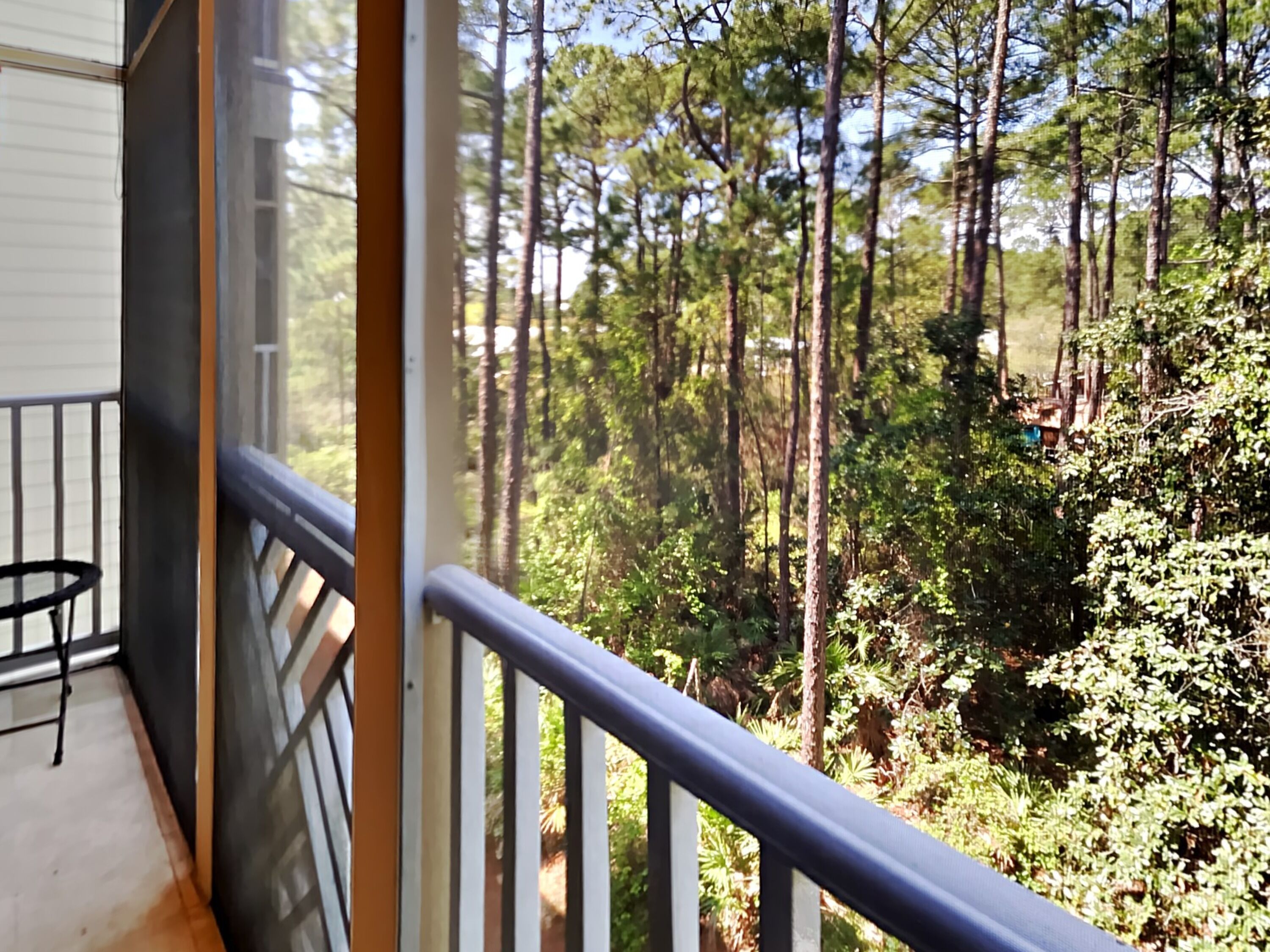 A balcony with a view of a forest.