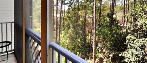 A balcony with a view of a forest.