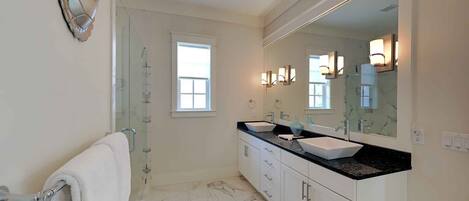 A bathroom with two sinks, a large mirror, and a towel rack.