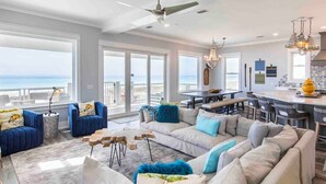 A spacious living room with a large sectional sofa, a dining area, and a kitchen. - The Oasis by Resort Collection (Panama City Beach)