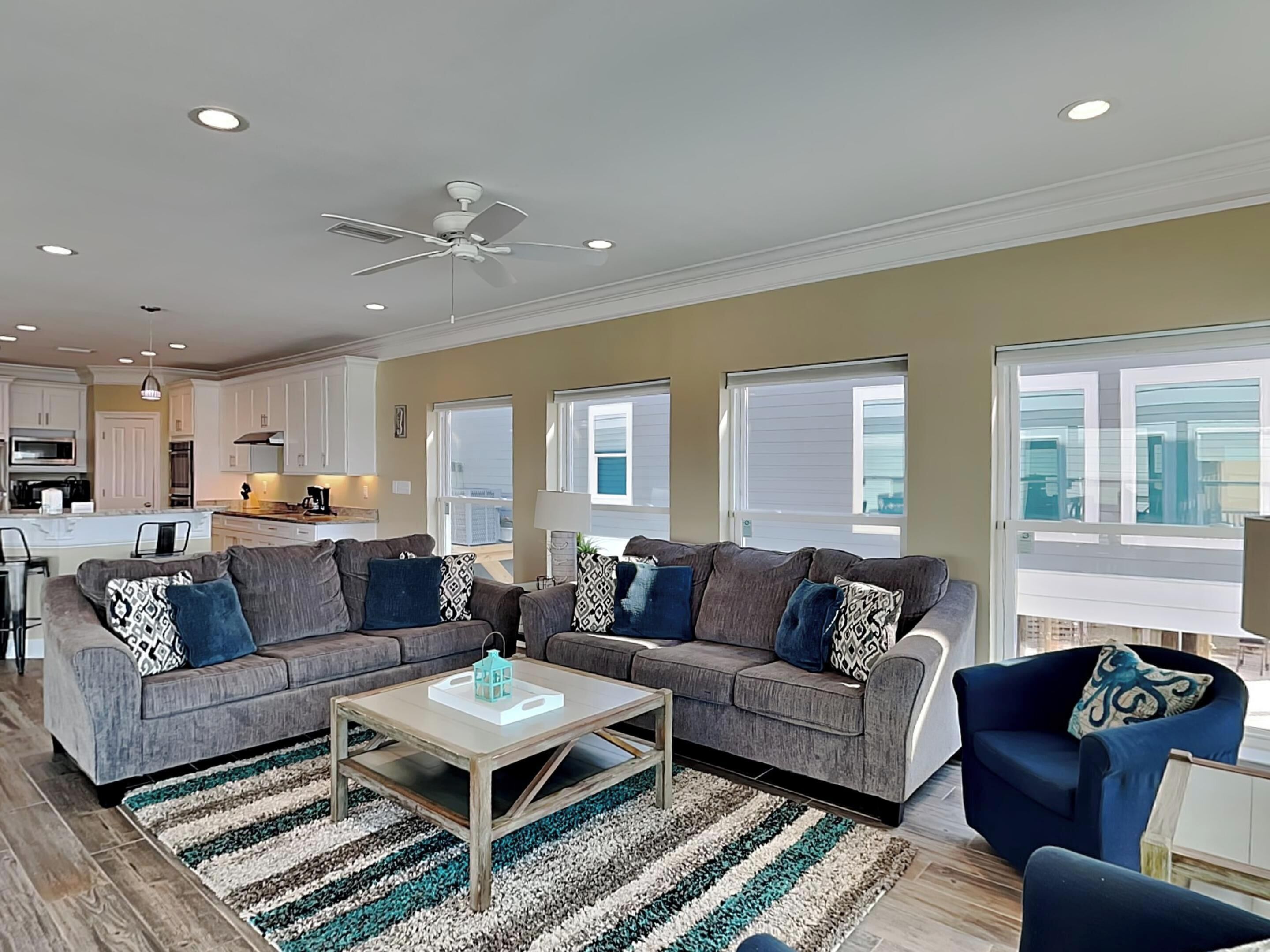 A modern living room with a grey sectional sofa, a coffee table, and a striped rug.